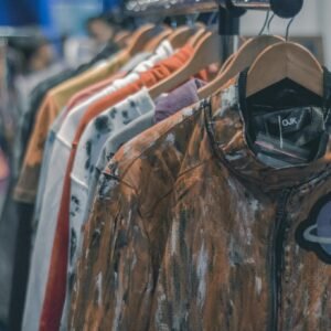 Colorful clothes hanging on a rack in a trendy retail store, showcasing fashion variety.